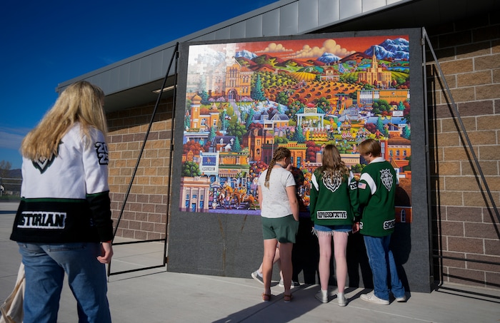 (Bethany Baker | The Salt Lake Tribune) Payson High School students look at a puzzle mural before a charity event to commemorate the 40th anniversary of the movie "Footloose" on the football field of Payson High School in Payson on Saturday, April 20, 2024.