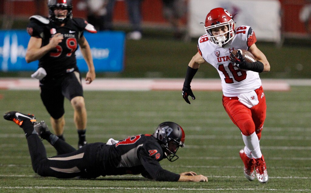 Utah's Britain Covey runs past Fresno State's Garrett Swanson for a touchdown during the second half of an NCAA college football game in Fresno, Calif., Saturday, Sept. 19, 2015. (AP Photo/Gary Kazanjian)