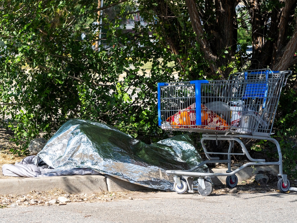 (Rick Egan | The Salt Lake Tribune) A person sleeps under a space blanket in the middle of the day, with temperatures in the 90's, on Monday, July 17, 2023.