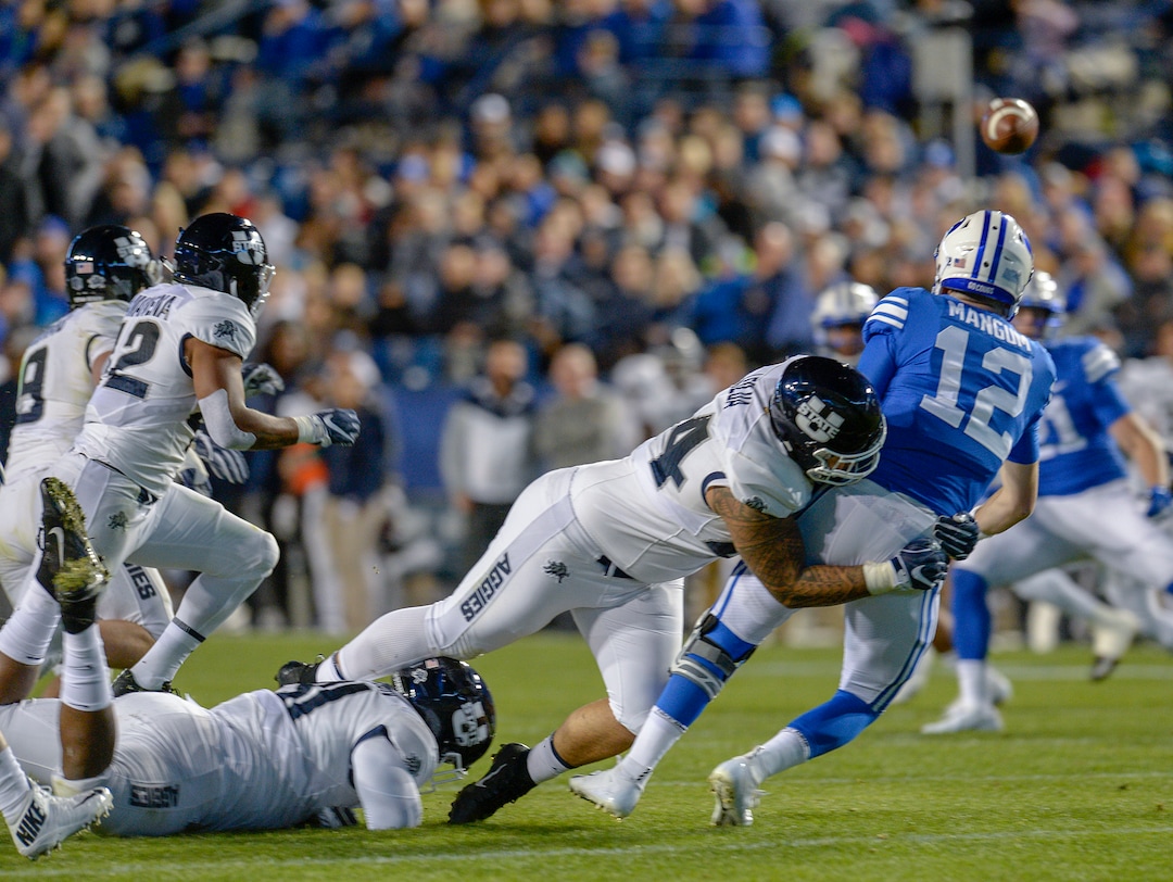 Leah Hogsten  |  The Salt Lake Tribune  Utah State Aggies defensive end Fua Leilua (44) pressures Brigham Young Cougars quarterback Tanner Mangum (12) to pass as BYU hosts Utah State University at Lavell Edwards Stadium in Provo, Friday, Oct. 5, 2018.