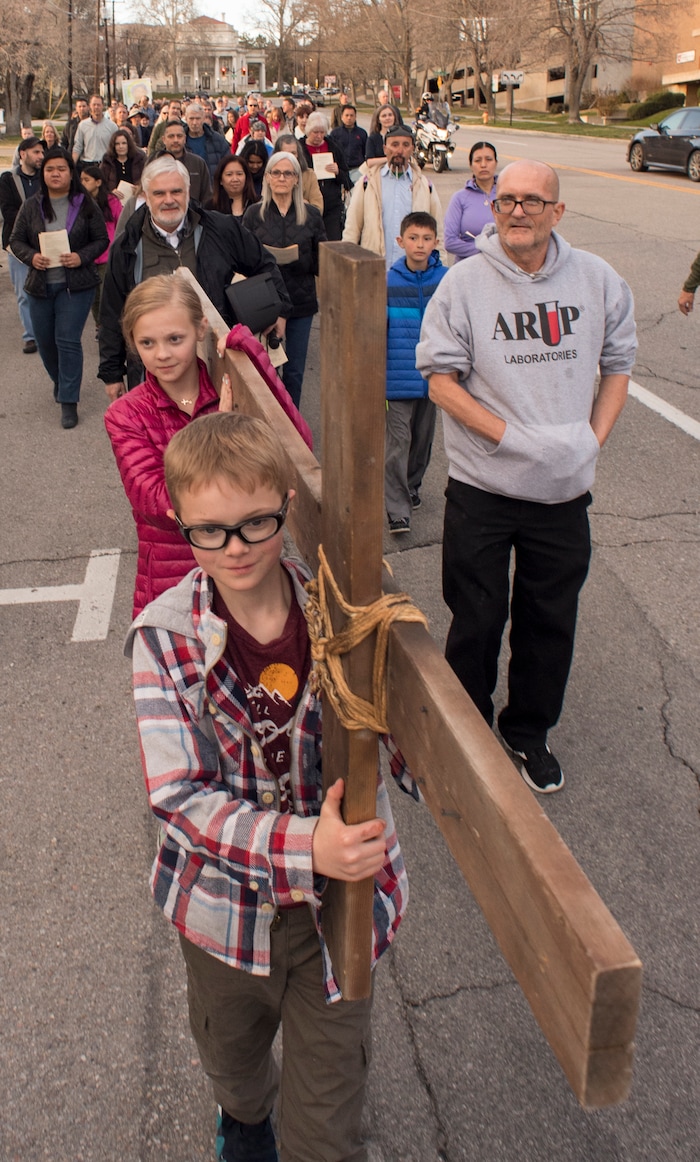 (Rick Egan  |  The Salt Lake Tribune)     Cal Burke, 11, and Grace Carlson, 12, from Layton, carry the cross as members of Christian denominations participate in the annual Good Friday procession through downtown Salt Lake City, Friday, March 30, 2018. The procession commemorating Christ's path to crucifixion has been a tradition of the Salt Lake Council of Churches since 1988. 


