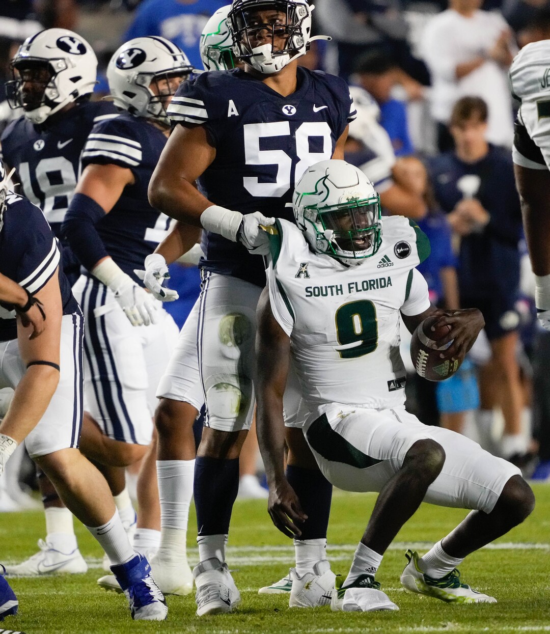 (Francisco Kjolseth | The Salt Lake Tribune) Brigham Young Cougars defensive lineman Uriah Leiataua (58) picks up South Florida Bulls quarterback Timmy McClain (9) after tackling him in game action between the Brigham Young Cougars and the South Florida Bulls at LaVell Edwards Stadium in Provo, Saturday, Sept. 25, 2021.