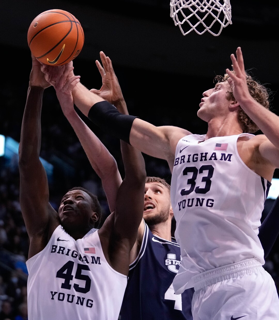 (Francisco Kjolseth | The Salt Lake Tribune) Brigham Young Cougars forward Fousseyni Traore (45) Utah State Aggies forward Brandon Horvath (4) and Brigham Young Cougars forward Caleb Lohner (33) battle for possession in basketball action between the Brigham Young Cougars and the Utah State Aggies at the Marriott Center in Provo, Wednesday, Dec. 8, 2021.