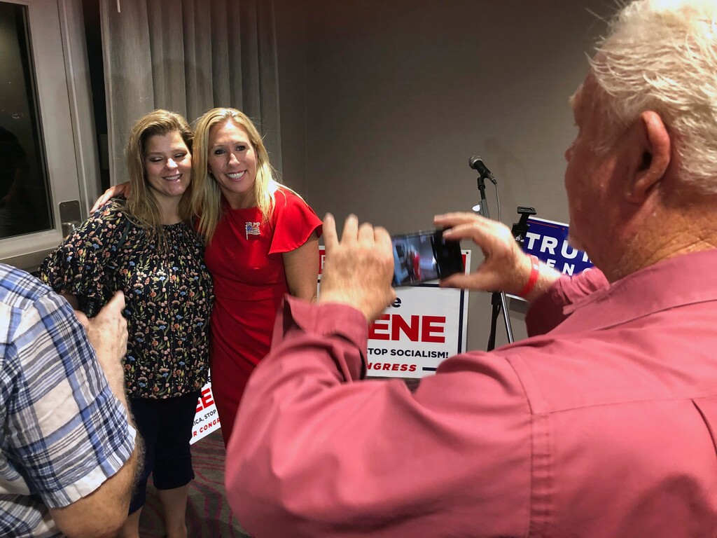 (Mike Stewart | AP photo)
Supporters take photos with construction executive Marjorie Taylor Greene, background right, late Tuesday, Aug. 11, 2020, in Rome, Ga. Greene, criticized for promoting racist videos and adamantly supporting the far-right QAnon conspiracy theory, won the GOP nomination for northwest Georgia's 14th Congressional District.