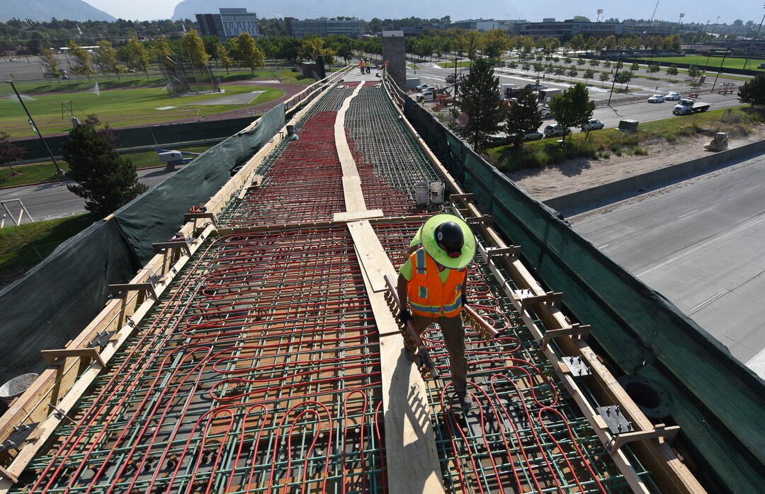 (Francisco Kjolseth  |  The Salt Lake Tribune) UDOT gives a tour of the state’s new longest pedestrian bridge on Thursday, August 20, 2020, connecting Utah Valley University in Orem to student housing and the community on the West side of I-15. Crews are finishing up an extensive hydronic heating system that will pump warm water to keep the bridge clear of snow in the winters, as it gets ready to pour concrete for the walking surface. UDOT will close I-15 in both directions this weekend for work on the nearly 1,000 foot bridge that is 15 feet wide to accommodate pedestrians, cyclists and scooters. Elevators and stairs with small ramps to push up bicycles will be on each side of the bridge.