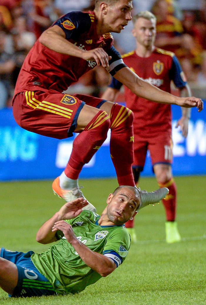 (Leah Hogsten  |  The Salt Lake Tribune) Real Salt Lake midfielder Damir Kreilach (8) jumps over Seattle Sounders midfielder Nicolas Lodeiro (10) as Real Salt Lake hosts the Seattle Sounders, Aug. 14, 2019, at Rio Tinto Stadium in Sandy. RSL defeated the Sounders 3-0.