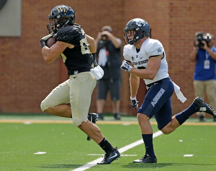 Wake Forest's Cam Serigne, left, outruns Utah State's Dallin Leavitt, right, for a touchdown after a catch in the first half of an NCAA college football game in Winston-Salem, N.C., Saturday, Sept. 16, 2017. (AP Photo/Chuck Burton)