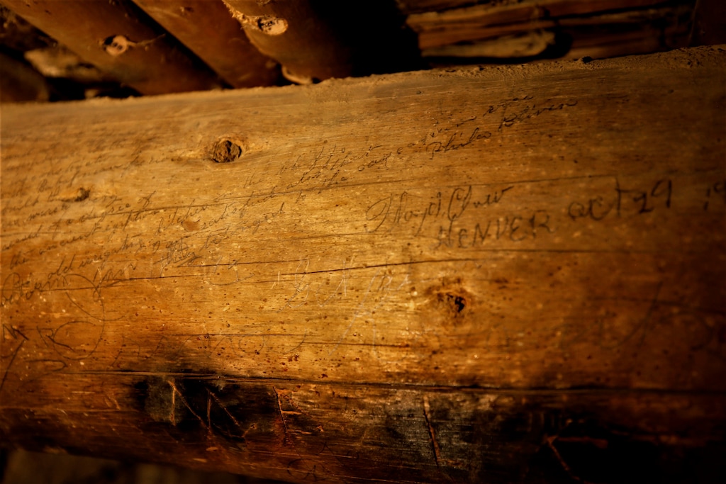 (Mike Easterling | The Daily Times via AP) In this Sept. 17, 2019 photo, a lengthy inscription by Phila Bliven covers the viga on the left side of this image in a room in the West Ruin at Aztec Ruins National Monument at Aztec, N.M. Her signature is visible at the top right of the viga. A Colorado historian is leading a team to survey the historic inscriptions on the ceilings of the 900-year-old ruins in northwestern New Mexico.