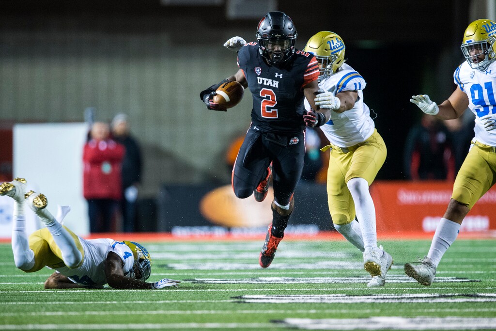 (Chris Detrick | The Salt Lake Tribune) Utah Utes running back Zack Moss (2) runs past UCLA Bruins defensive back Jaleel Wadood (4) UCLA Bruins defensive lineman Keisean Lucier-South (11) and UCLA Bruins defensive lineman Jacob Tuioti-Mariner (91) during the game at Rice-Eccles Stadium Friday, November 3, 2017.