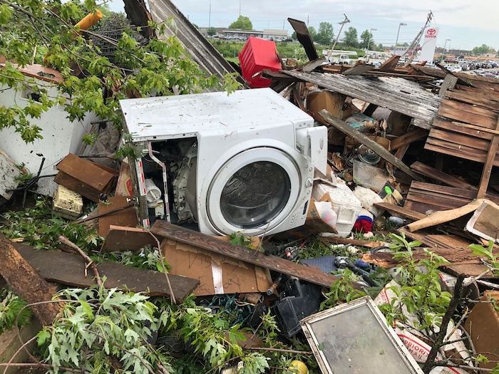 (Summer Ballentine | AP) Debris from a home that David Surprenant rents with his family is scattered across the lawn Thursday, May 23, 2019, the morning after a tornado hit Jefferson City, Mo. Surprenant said his family fled to the basement while he watched the sky outside.  Officials are going door-to-door to survey damage after a tornado ripped a 3-mile path through Missouri's capital city. The destruction in Jefferson City was part of an outbreak of severe weather overnight.