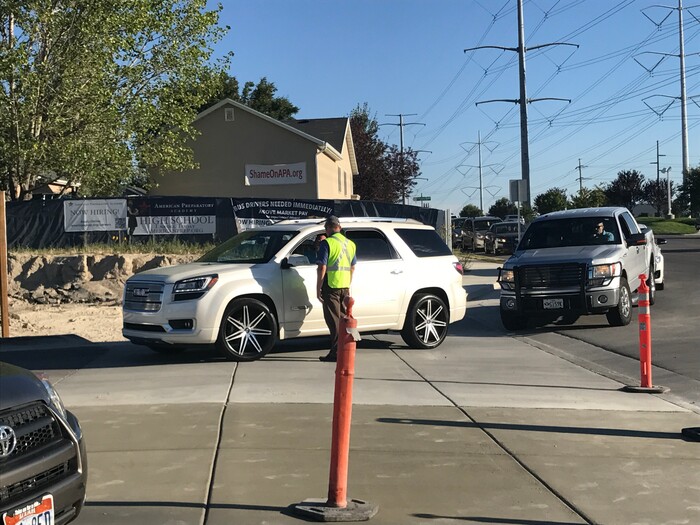 (Benjamin Wood | The Salt Lake Tribune)   Faculty members with American Preparatory Academy in Draper helped direct traffic as families arrived Monday for the first day of the 2017-2018 school year.