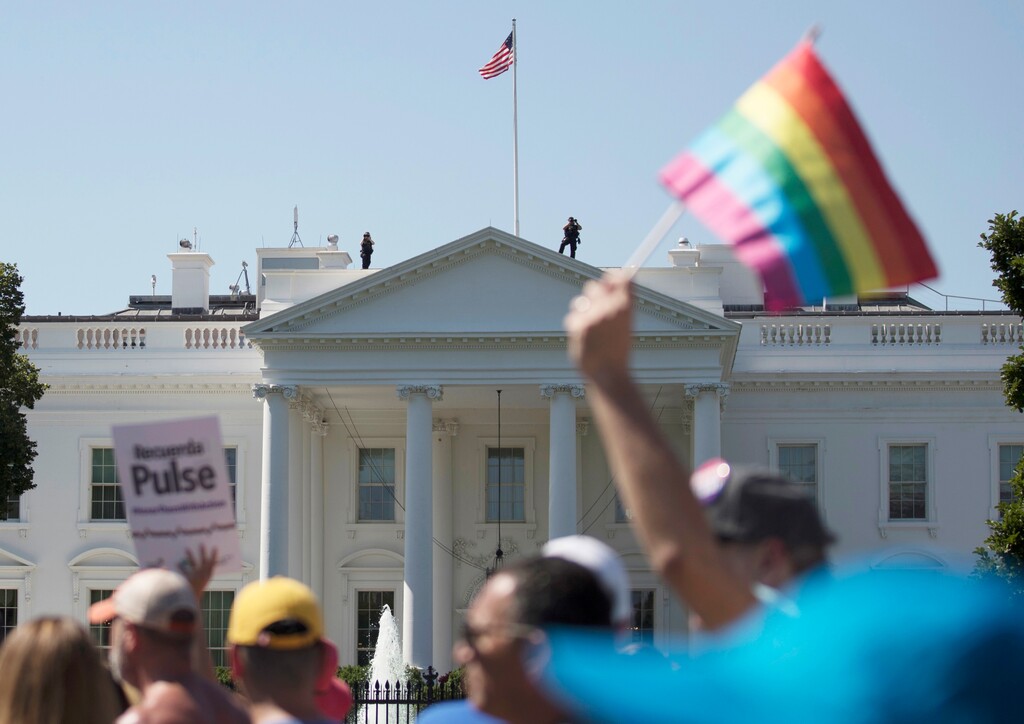 FILE - In this Sunday, June 11, 2017 file photo, Equality March for Unity and Pride participants march past the White House in Washington. A federal court in Washington is barring President Donald Trump from changing the government's policy on military service by transgender people.  (AP Photo/Carolyn Kaster)