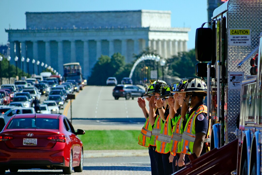 (Danny La | Special to The Tribune) Near the entrance of Arlington National Cemetery,  Arlington and Alexandria Fire Department firefighters pay their respects during the funeral procession for Staff Sgt. Taylor Hoover on Friday, Sept. 24, 2021. Hoover was killed in action due to a suicide bombing in Kabul, Afghanistan on Aug. 26.