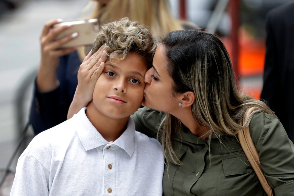 Sirley Silveira Paixao, an immigrant from Brazil seeking asylum, kisses her 10-years-old son Diego Magalhaes, after Diego was released from immigration detention, Thursday, July 5, 2018, in Chicago. (AP Photo/Charles Rex Arbogast)