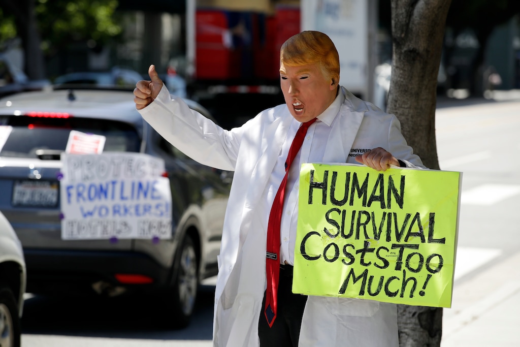 (Marcio Jose Sanchez | AP photo)

A protester wears a Donald Trump mask as he gives a thumbs up to a procession of vehicles participating in a drive-by protest outside of Providence Saint John's Health Center April 21 in Santa Monica, Calif. The hospital suspended ten nurses from their jobs last week after they refused to care for COVID-19 patients without being provided protective N95 face masks.