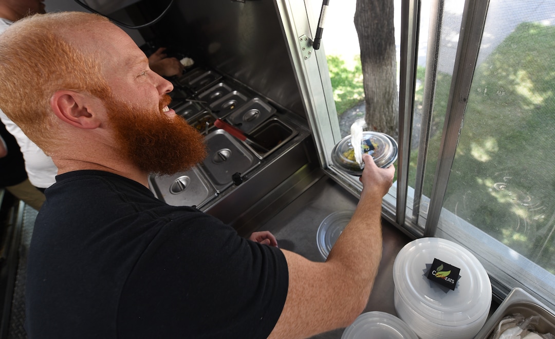 (Francisco Kjolseth  |  The Salt Lake Tribune)  Co-owner Jared Trust delivers an order from the window of the Clean Eats food truck with a friendly "Have a great day!"