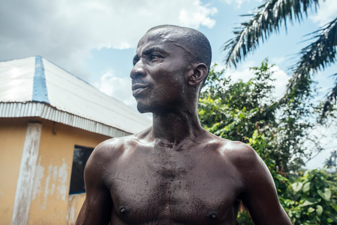 (KC Nwakalor | The New York Times) Azubuike Osi works on his family's cassava farm in Obrikom, in the heart of Nigeria's oil-rich delta, July 21, 2020. Around the world, the poor and marginalized are much more likely to be vulnerable to extreme heat; methane gas flares burning around the clock in Obrikom make this already hot area worse still.