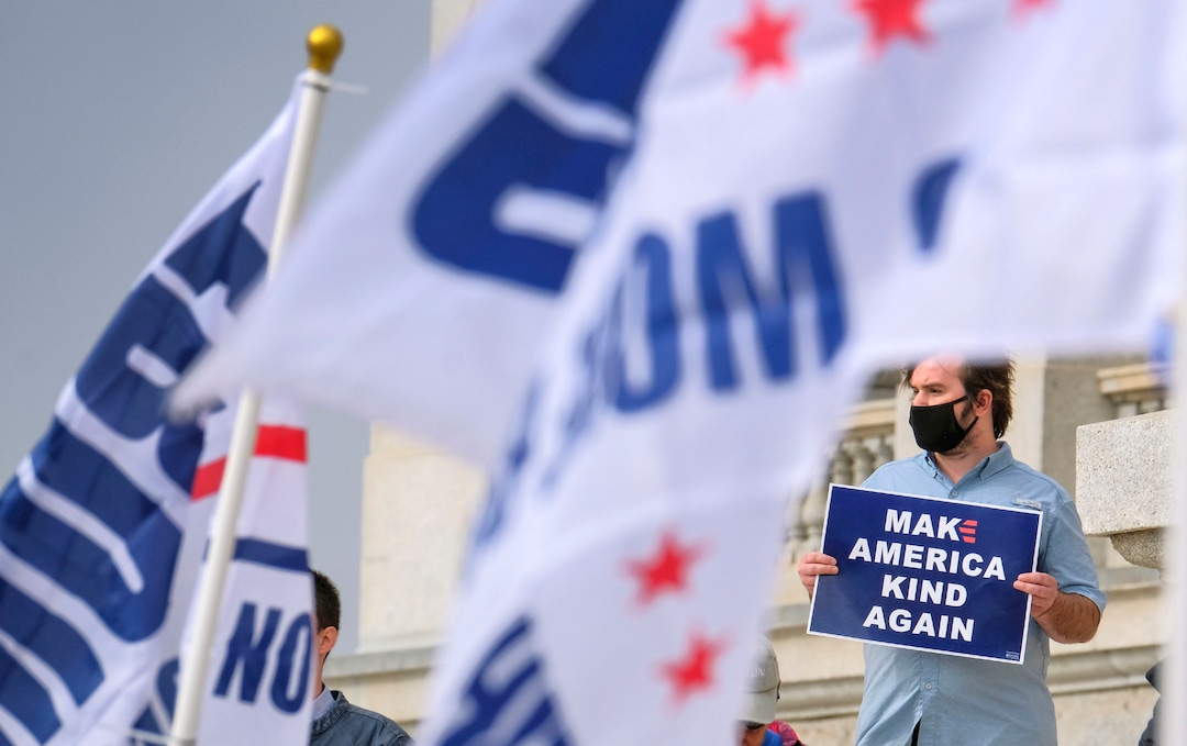 (Leah Hogsten  |  The Salt Lake Tribune) Amid a sea of President Donald Trump supporters, Kaden from Salt Lake City holds a Joe Biden sign. As news broke of former Vice President Joe Biden earning enough Electoral College votes to secure the presidency Saturday, Trump protesters took to the Capitol to denounce the win.