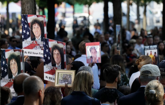 (Mark Lennihan | AP Photo) Family members hold up photos during a ceremony marking the 18th anniversary of the attacks of Sept. 11, 2001 at the National September 11 Memorial, Wednesday, Sept. 11, 2019 in New York.