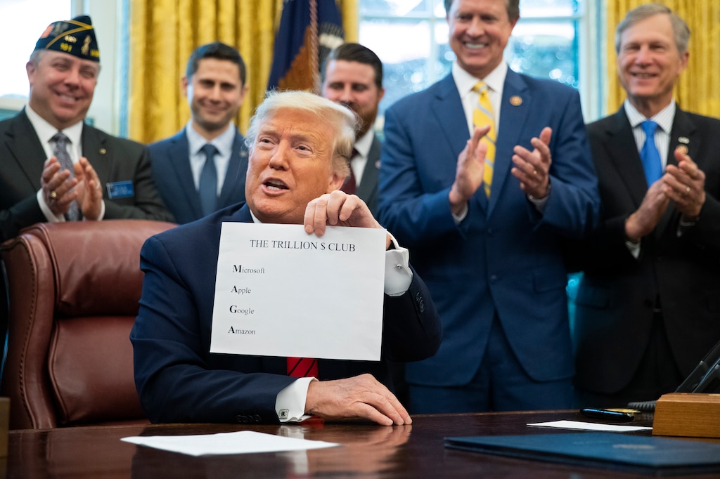 FILE - In this Tuesday, Feb. 11, 2020 file photo, President Donald Trump holds a sheet of paper with the names of four U.S. companies worth over a trillion dollars to emphasize how well the economy is doing during the Supporting Veterans in STEM Careers Act signing ceremony in the Oval Office at the White House in Washington. He noted that the first letters of the companies spells "MAGA" (Make America Great Again). (AP Photo/Manuel Balce Ceneta)