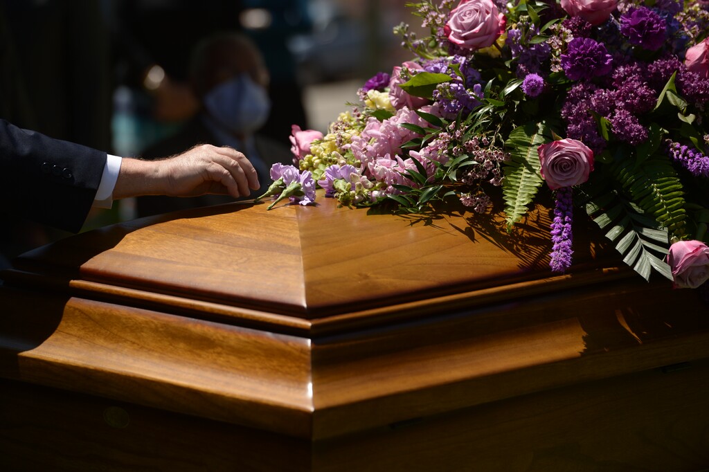 (Leah Hogsten  |  The Salt Lake Tribune file photo ) Family members surround the gravesite of a Utah woman who was buried Friday, May 8, 2020, at the Salt Lake City Cemetery. She died from COVID-19.