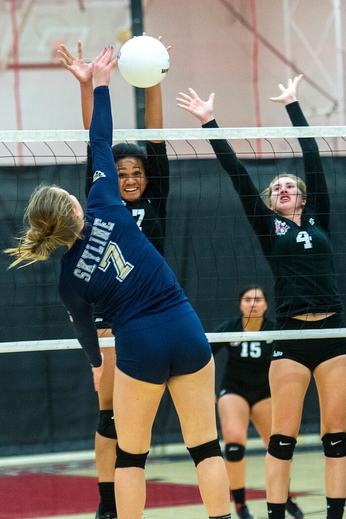 (Chris Detrick | The Salt Lake Tribune) Skyline's Anna Pingree (7) spikes the ball past West's Dana Manu (7) and West's Afton WylieÊ(4) during the volleyball match at West High School Tuesday, October 3, 2017.