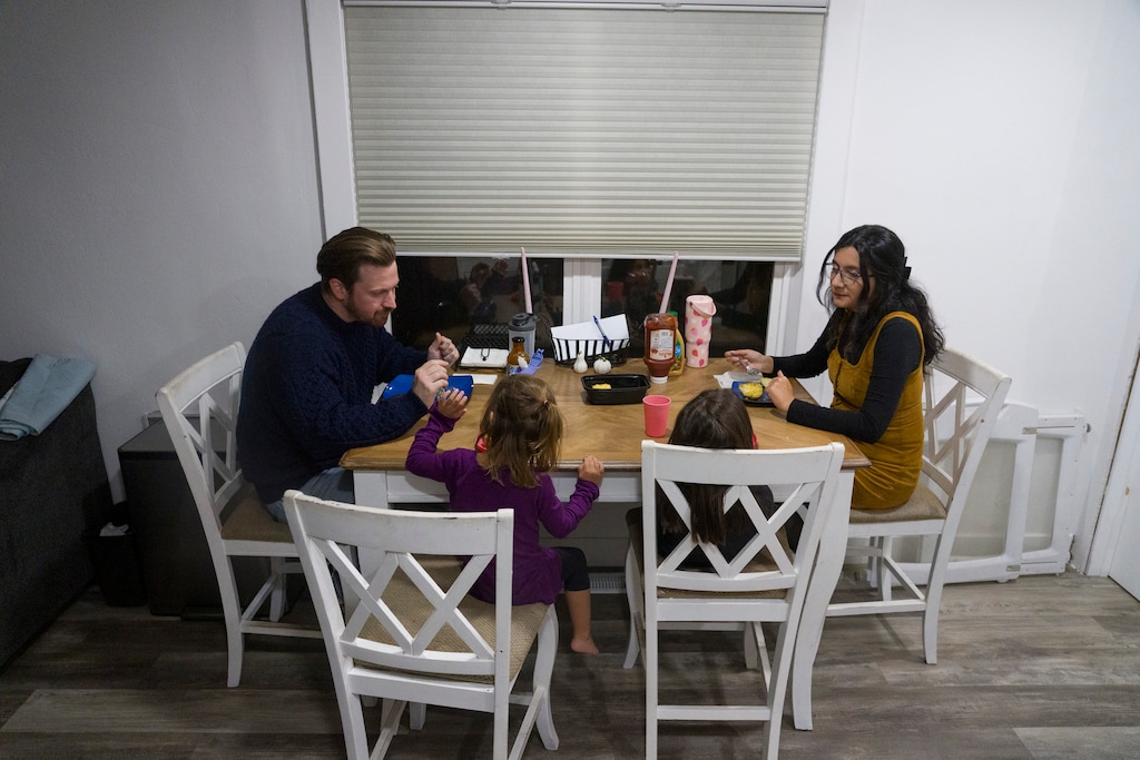 (Bethany Baker | The Salt Lake Tribune) Mackenzie Miller, left, and Nia Delgado, right, eat dinner with Miller's daughters at their home in Magna on Monday, Nov. 17, 2025. Miller's daughters attend a county day care program.