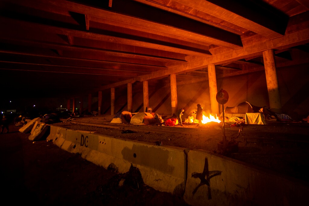 (Rick Egan | The Salt Lake Tribune)  A few of the remaining campers warm themselves by the fire under the freeway over pass, on the last night of Camp Last Hope, on Wednesday, Feb. 3, 2021.
