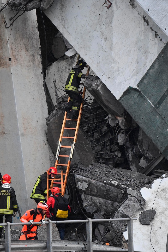 Rescues work among the debris of the collapsed Morandi highway bridge in Genoa, Tuesday, Aug. 14, 2018. Italian authorities say that about 10 vehicles were involved when the raised highway collapsed during a sudden and violent storm in the northern port city of Genoa, while private broadcaster Sky TG24 said the collapsed section was about 200-meter long (650 feet). (Luca Zennaro/ANSA via AP)