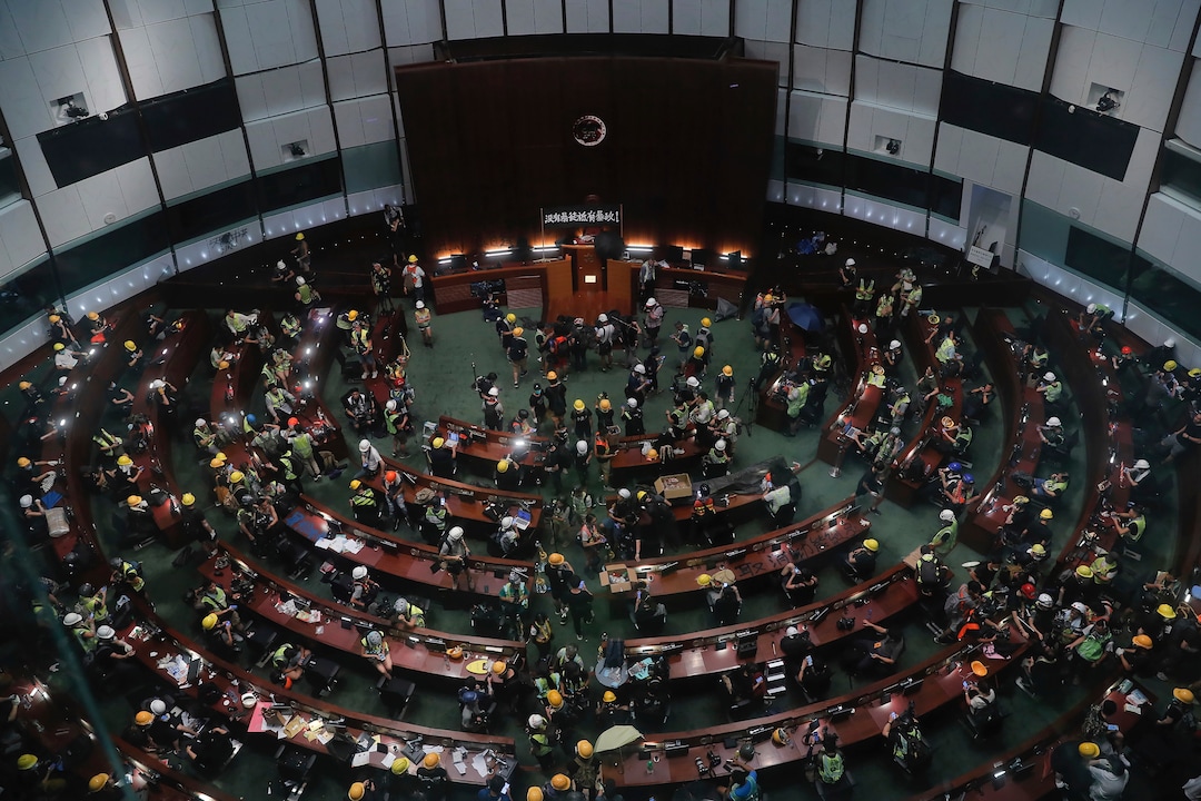 (Kin Cheung | AP Photo) Protesters gather inside the meeting hall of the Legislative Council in Hong Kong, Monday, July 1, 2019. Protesters in Hong Kong took over the legislature's main building Friday night, tearing down portraits of legislative leaders and spray painting pro-democracy slogans on the walls of the main chamber.