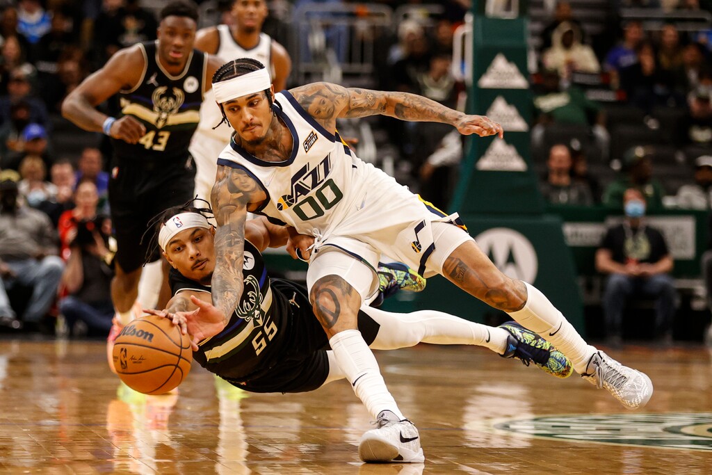 (Jeffrey Phelps | AP) Milwaukee Bucks guard Justin Robinson (55) and Utah Jazz guard Jordan Clarkson (00) reach for the ball during the second half of an NBA basketball game Sunday, Oct. 31, 2021, in Milwaukee.