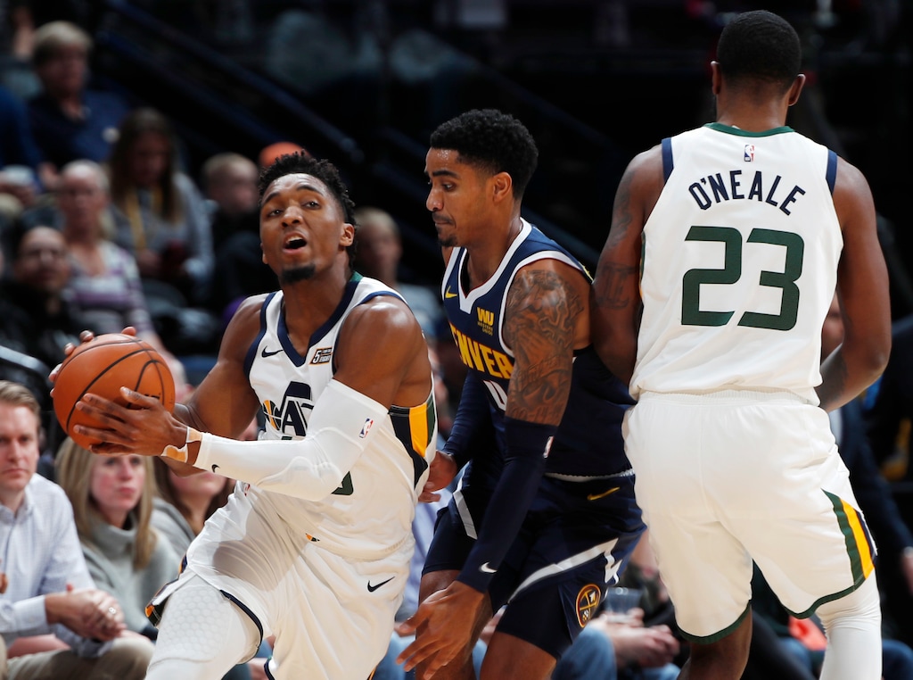 Utah Jazz guard Donovan Mitchell, left, fields a pass as forward Royce O'Neale, right, sets a pick on Denver Nuggets guard Gary Harris during the first half of an NBA basketball game Saturday, Nov. 3, 2018, in Denver. (AP Photo/David Zalubowski)