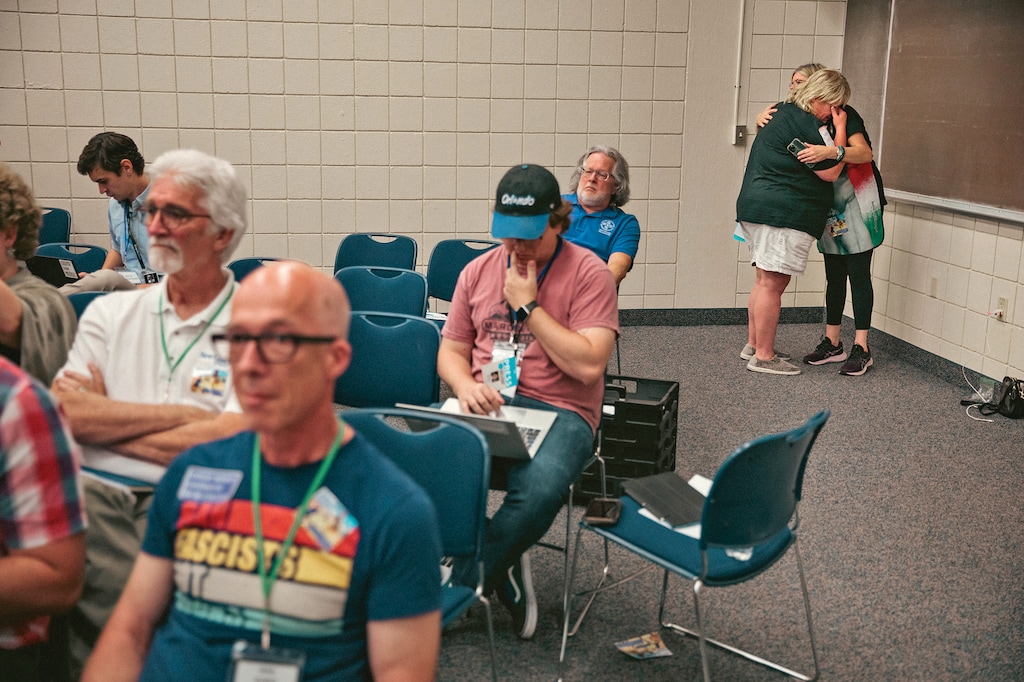 A New College parent who broke down in tears after speaking is consoled at a board of trustees meeting in Sarasota, Fla., April 26, 2023. For many, the meeting was the clearest sign yet that this is the last semester of New College as they know it, Michelle Goldberg writes. (Damon Winter/ The New York Times)