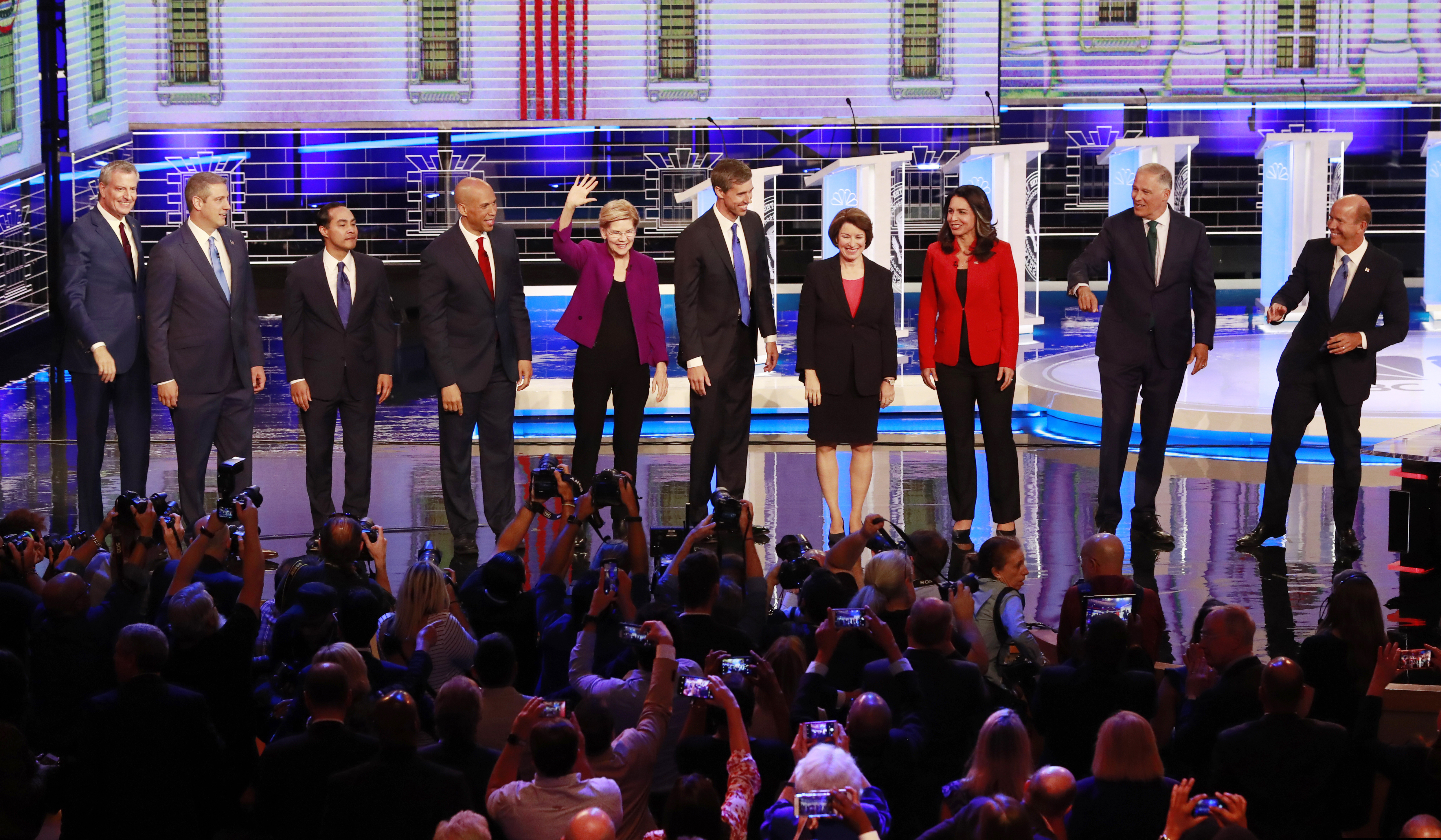 (Wilfredo Lee | AP Photo) From left, New York City Mayor Bill de Blasio, Rep. Tim Ryan, D-Ohio, former Housing and Urban Development Secretary Julian Castro, Sen. Cory Booker, D-N.J., Sen. Elizabeth Warren, D-Mass., former Texas Rep. Beto O’Rourke, Sen. Amy Klobuchar, D-Minn., Rep. Tulsi Gabbard, D-Hawaii, Washington Gov. Jay Inslee, and former Maryland Rep. John Delaney pose for a photo on stage before the start of a Democratic primary debate hosted by NBC News at the Adrienne Arsht Center for the Performing Arts, Wednesday, June 26, 2019, in Miami.