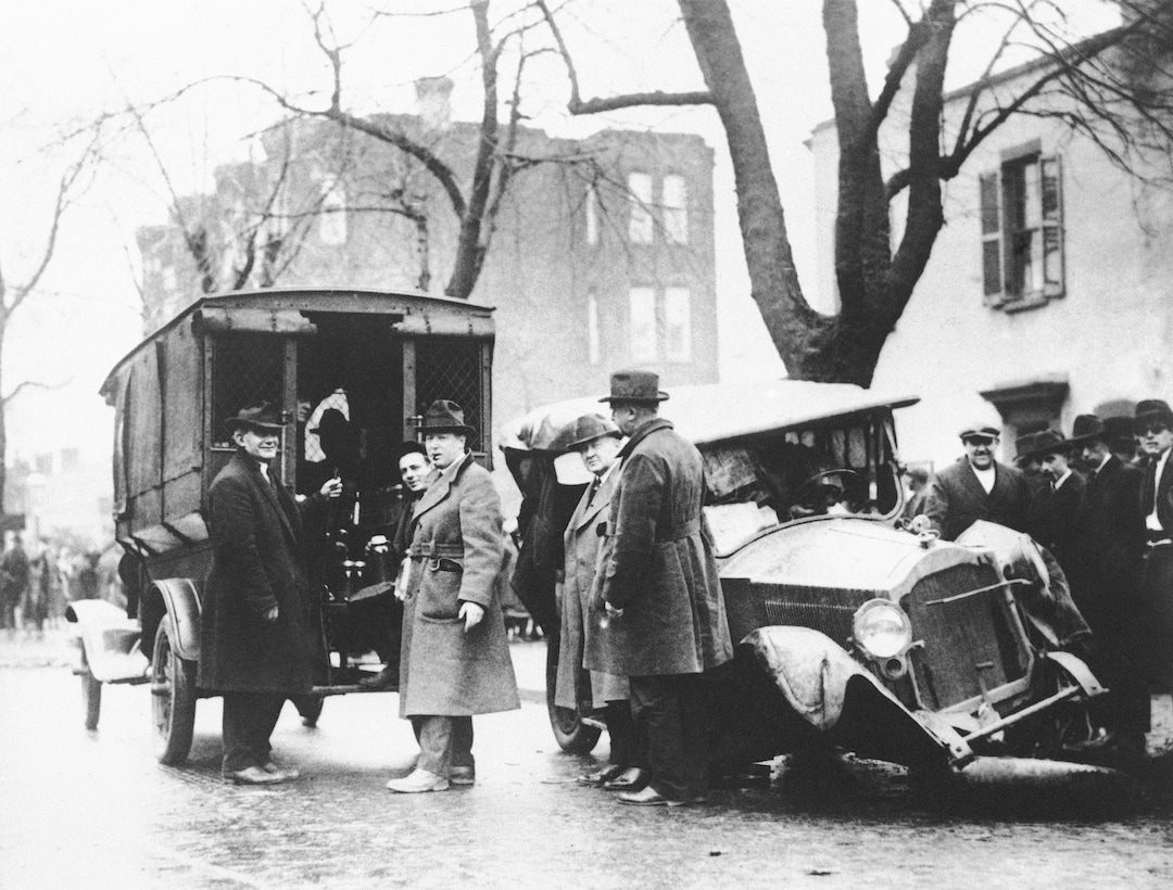 FILE - In this Jan. 23, 1922, file photo a patrol wagon filled with confiscated moonshine sits next to a wrecked car of bootleggers in Washington. Prohibition greatly expanded federal law enforcement powers and turned millions of Americans into scofflaws. It provided a new revenue stream for organized crime. (AP Photo, File)
