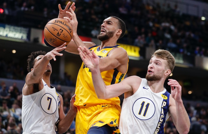 Utah Jazz center Rudy Gobert (27) loses the ball between Indiana Pacers forward Domantas Sabonis (11) and guard Malcolm Brogdon (7) during the second half of an NBA basketball game in Indianapolis, Wednesday, Nov. 27, 2019. The Pacers won 121-102. (AP Photo/Michael Conroy)