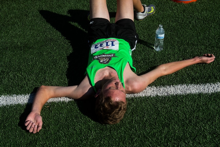 (Chris Detrick  |  The Salt Lake Tribune)  Desert Hills senior Bryson King remains on the ground after competing in the 4A boy's state cross-country meet at Sugar House Park and Highland High School Wednesday, October 18, 2017. 