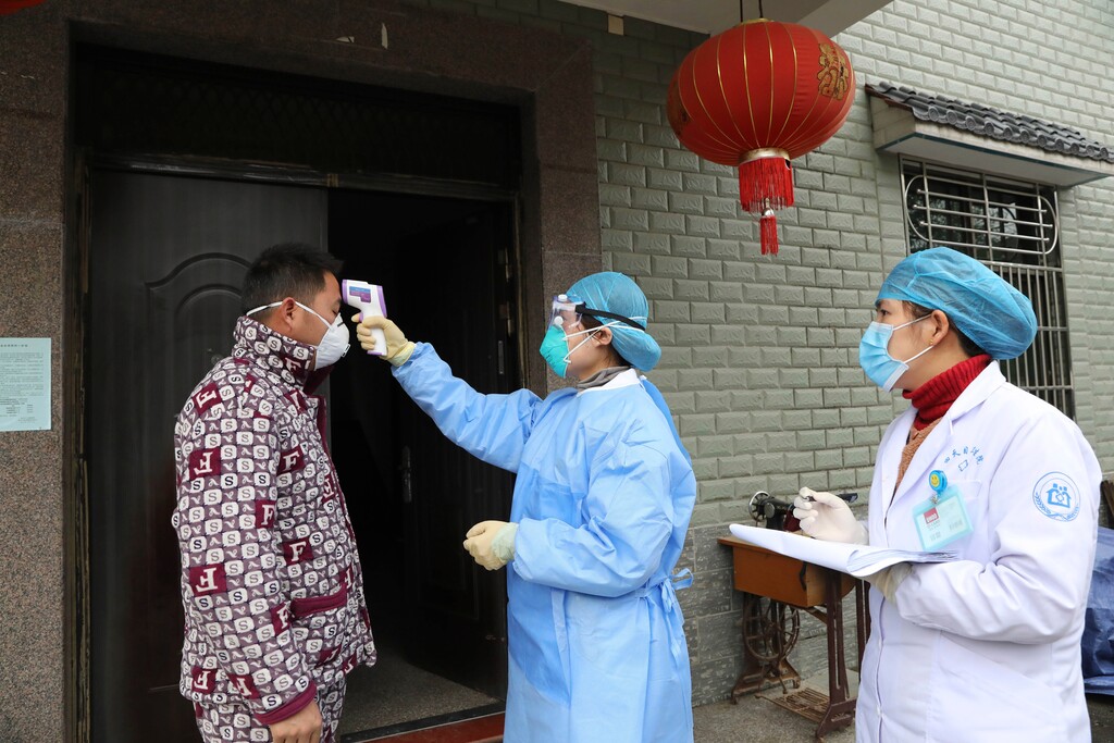 (Chinatopix via AP) In this Jan. 27, 2020 photo, community health workers check the temperature of a person who recently returned from Hubei Province, center of a virus outbreak, in Hangzhou in eastern China's Zhejiang Province. As China institutes the largest quarantine in human history, locking down more than 50 million people in the center of the country, those who have recently been to Wuhan are being tracked, monitored, turned away from hotels and shoved into isolation at their homes and in makeshift quarantine facilities.