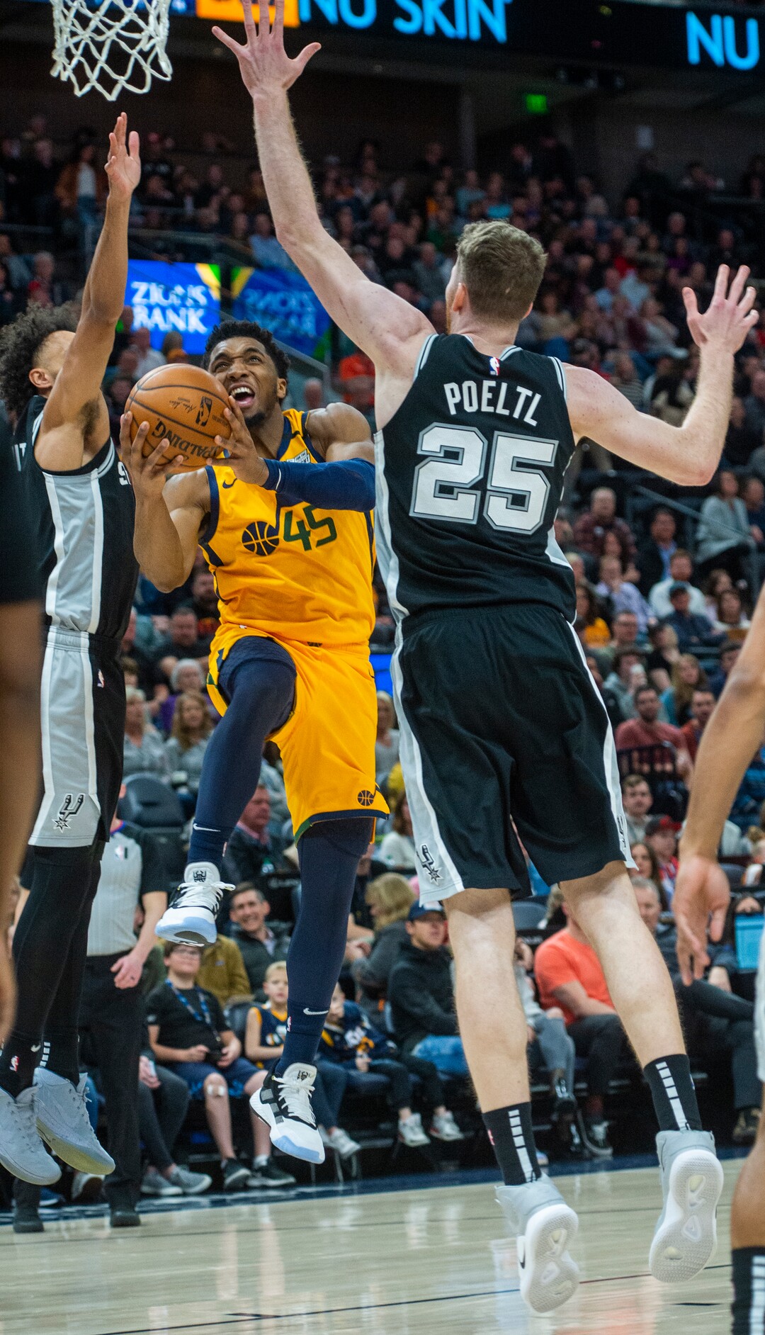 (Rick Egan  |  The Salt Lake Tribune)    Utah Jazz guard Donovan Mitchell (45) takes the ball to the hoop, as San Antonio Spurs center Jakob Poeltl (25) defends, in NBA action between the Utah Jazz and the San Antonio Spurs, in Salt Lake City, Friday, Feb. 21, 2020.