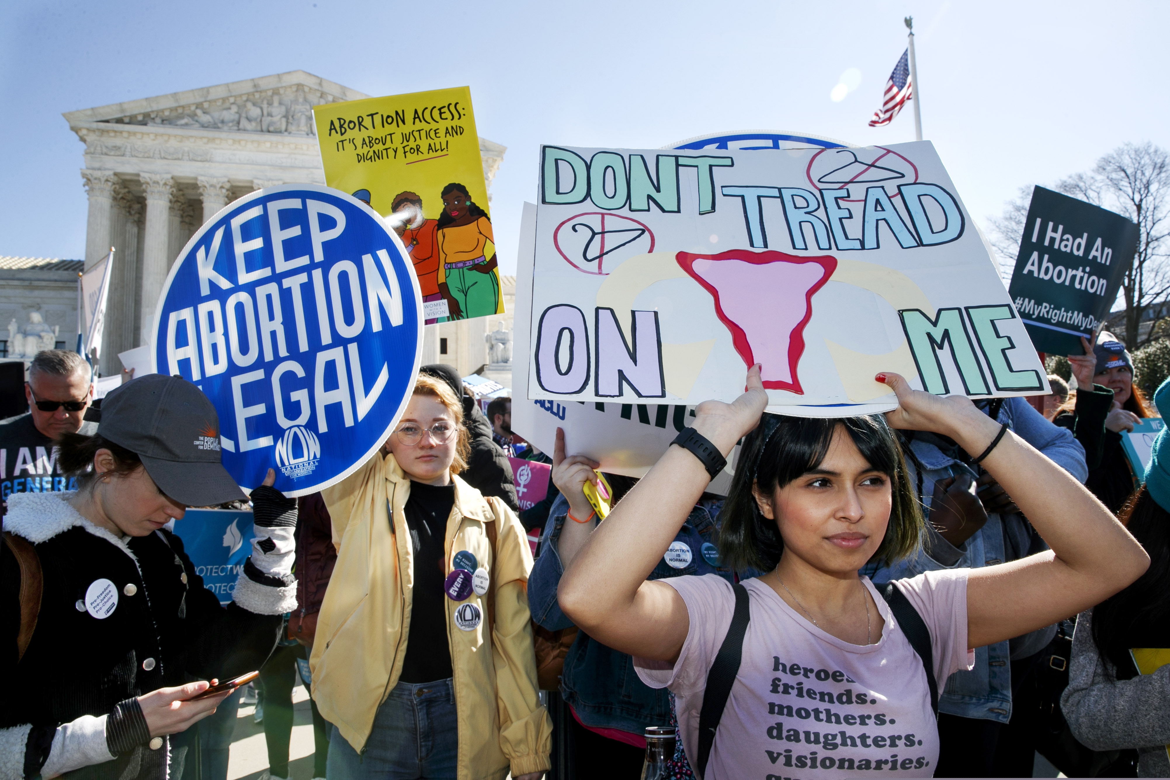 FILE - In this Wednesday, March 4, 2020 file photo, abortion rights demonstrators including Jaylene Solache, of Dallas, Texas, right, rally outside the Supreme Court in Washington. In some states, the 2020 COVID-19 coronavirus outbreak has fueled attempts to ban abortions. Where the procedure remains available, some abortion providers report increased demand, often from women distraught over economic stress and health concerns linked to the pandemic. (AP Photo/Jacquelyn Martin)
