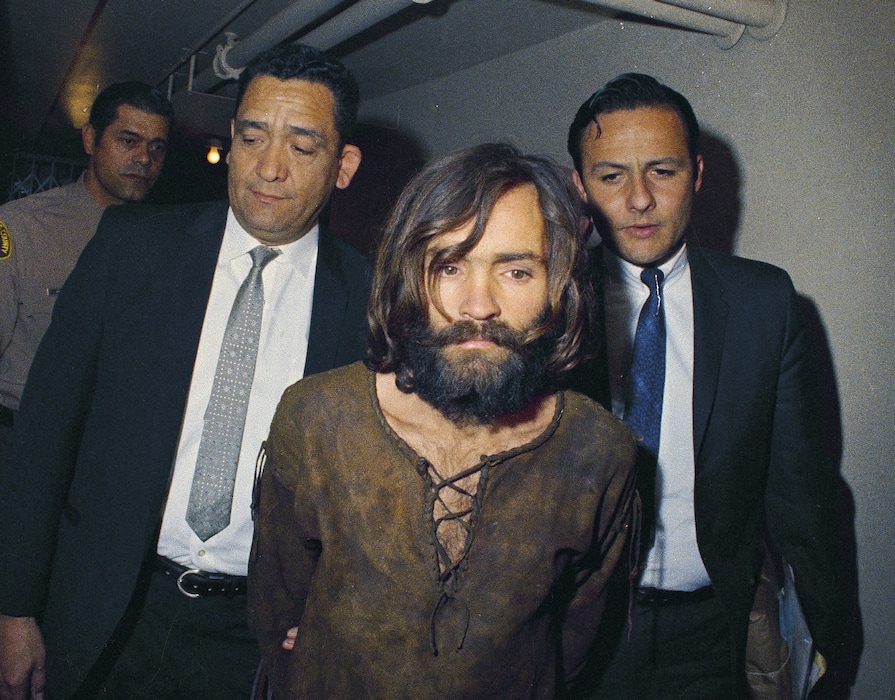 (AP Photo, File) In this 1969 file photo, Charles Manson is escorted to his arraignment on conspiracy-murder charges in connection with the Sharon Tate murder case. Authorities say Manson, cult leader and mastermind behind 1969 deaths of actress Sharon Tate and several others, died on Sunday, Nov. 19, 2017. He was 83.