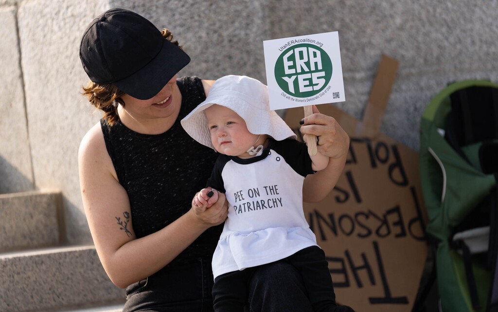(Francisco Kjolseth | The Salt Lake Tribune) Miranda Gilvarry holds her daughter as they join the rally on Women’s Equality Day at the Capitol on Thursday, Aug. 26, 2021, to encourage Utah to ratify the Equal Rights Amendment.