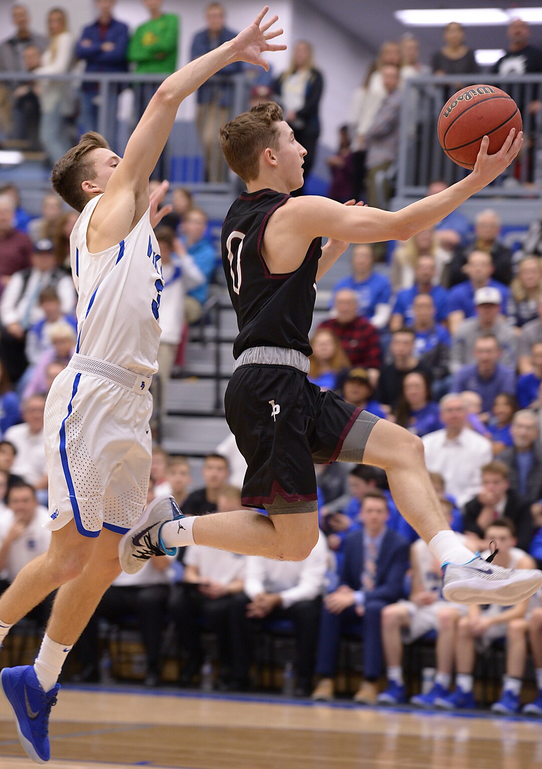 (Leah Hogsten  |  The Salt Lake Tribune) Lone Peak's Chantry Ross skies to the net around Pleasant Grove's .  Pleasant Grove's Casey Brown. High School boys' basketball team leads Lone Peak High School 26-20 during their game Friday, January 26, 2018 in Pleasant Grove. 