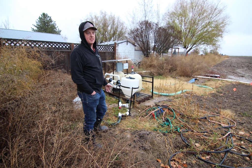 (Jeff Dahdah | KSL) Farmer Kelby Johnson stands next to a water cleaning system for drip line irrigation on his property in Benson.