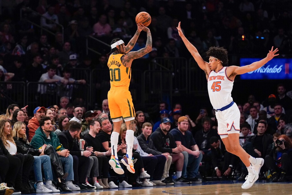 Utah Jazz's Jordan Clarkson, left, shoots over New York Knicks' Jericho Sims during the first half of an NBA basketball game, Sunday, March 20, 2022, in New York. (AP Photo/Seth Wenig)