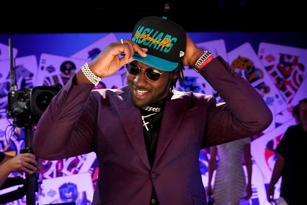 Utah linebacker Devin Lloyd puts on a hat after being chosen by the Jacksonville Jaguars with the 27th pick of the NFL football draft Thursday, April 28, 2022, in Las Vegas. (AP Photo/John Locher)
