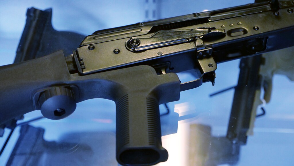 FILE - In this Oct. 4, 2017 file  photo, a device called a "bump stock" is attached to a semi-automatic rifle at the Gun Vault store and shooting range in South Jordan, Utah. The Trump administration is proposing banning bump stocks, which allow guns to mimic fully automatic fire and were used in last year's Las Vegas massacre. The Justice Department's regulation, announced Saturday, March 10, 2018, would classify the device as a machine gun prohibited under federal law. The move was expected after President Donald Trump ordered officials to work toward a ban after 17 people were killed at a Florida high school.  (AP Photo/Rick Bowmer, File)