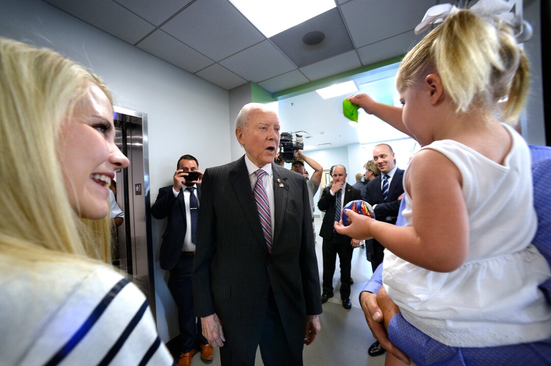 (Scott Sommerdorf   |  The Salt Lake Tribune)  Sen. Orrin Hatch is offered a balloon by Elizabeth Smart's daughter Chloe prior to the group touring the Utah State Crime Lab, Thursday, July 6, 2017.
