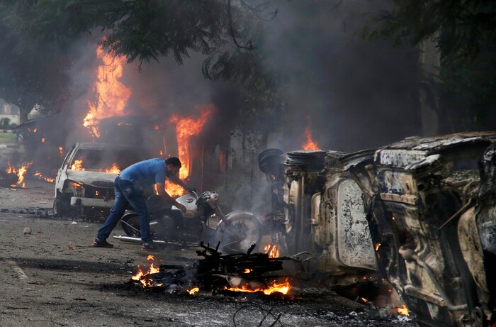 A man lifts a motorbike in a vandalized area by Dera Sacha Sauda sect members in Panchkula, India, Friday, Aug. 25, 2017. Deadly riots have broken out in a north Indian town after a court convicted a guru of raping two of his followers. Mobs also attacked journalists and set fire to government buildings and railway stations. (AP Photo/Altaf Qadri)