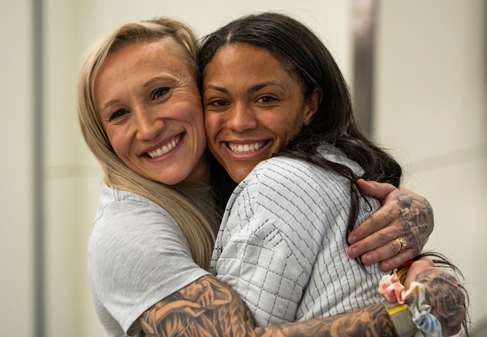 (Rick Egan | The Salt Lake Tribune) Kaillie Humphries, left, hugs two-woman bobsled teammate, Kaysha Love from Herriman, as they and other Team USA Olympians arrive at the Salt Lake City International Airport on Monday, Feb. 21, 2022.